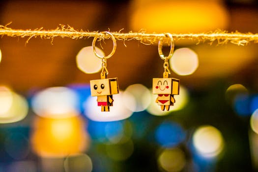 Colorful cartoon keychains hanging on a string with a vibrant bokeh background.