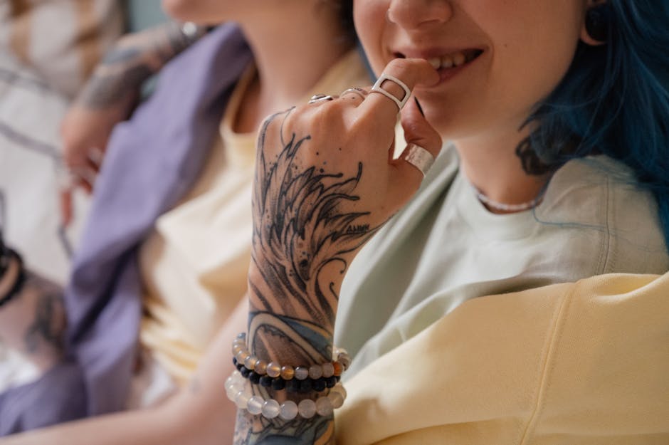 Close-up of a tattooed hand with rings and bracelets, capturing modern fashion and style.